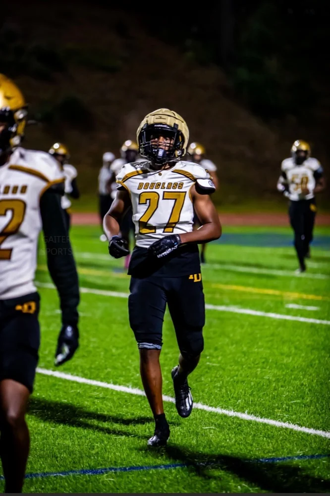 Travis Isaacs jogging onto the field under the lights